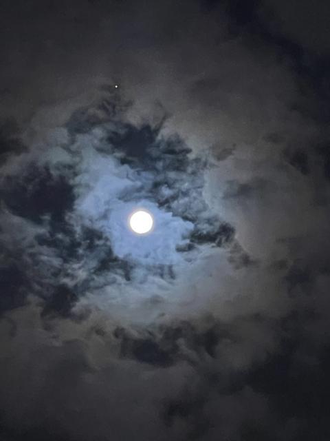 View of the full moon through the clouds