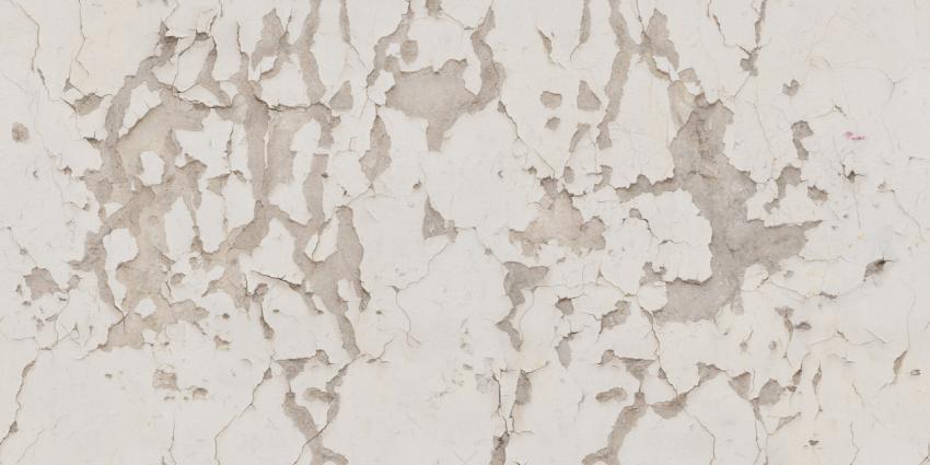 Texture of the old light wall surface with deep cracks and falling paint