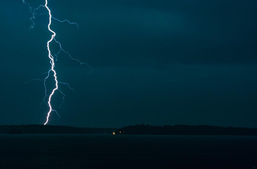 lightning strikes the sky over a body of water