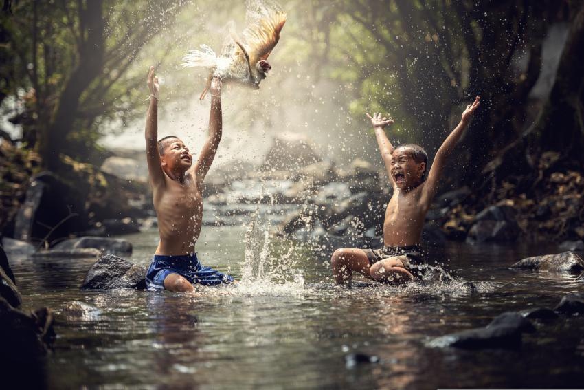 The boys are playing in the river