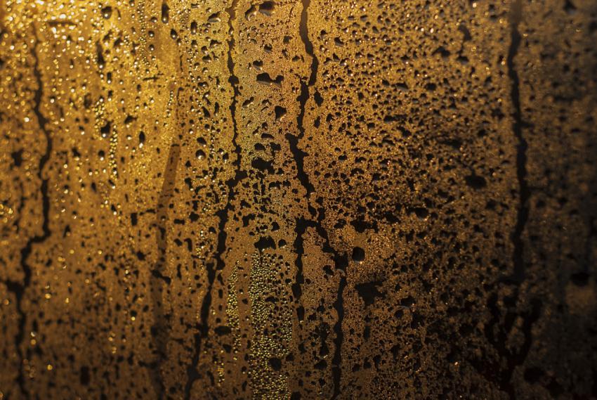 Raindrops on glass against the background of the sun