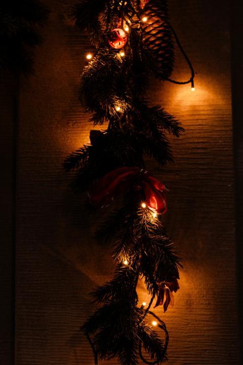 A Christmas garland with lights and a teddy bear